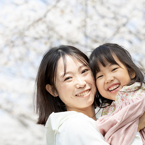 ママと抱っこしてもらっている幼い女の子の笑顔の瞬間