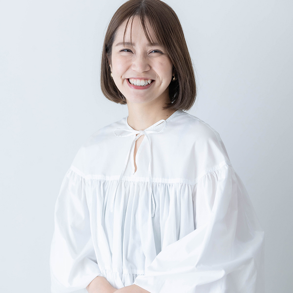 白いブラウスを着た女性の自然で満遍な笑顔のプロフィール写真