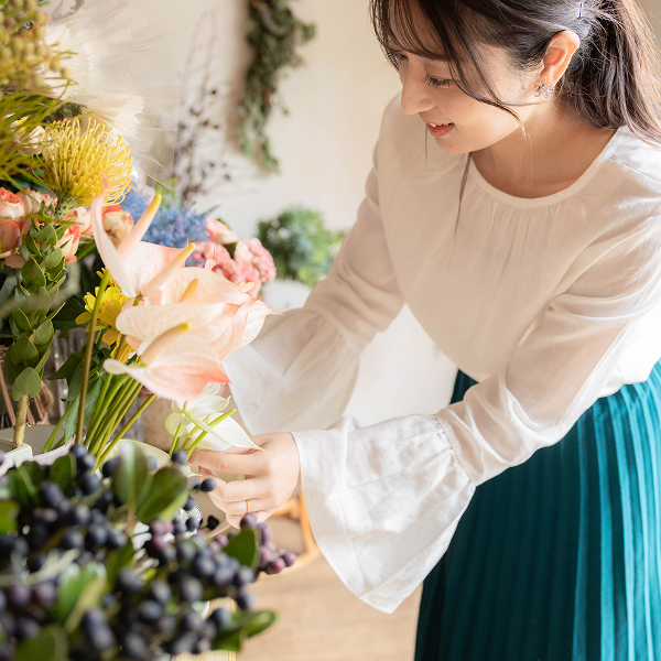 フラワーアーティストが花を楽しみながら整えている