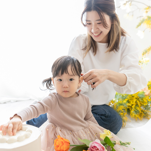 ミモザ撮影会のスタジオにてママに髪の毛を整えてもらっている女の子